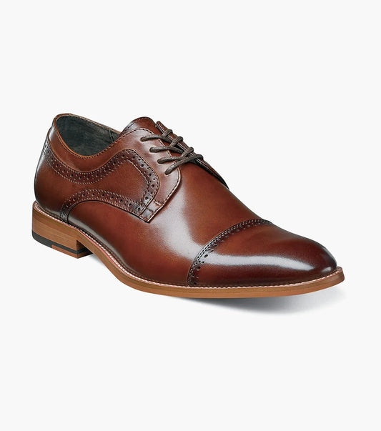 The Stacy Adams - DICKINSON Cap Toe Oxford in Cognac (25066-221) showcases a Leather Upper with decorative perforations, lace-up closure, and Memory Foam for enhanced comfort, all displayed on a white background.