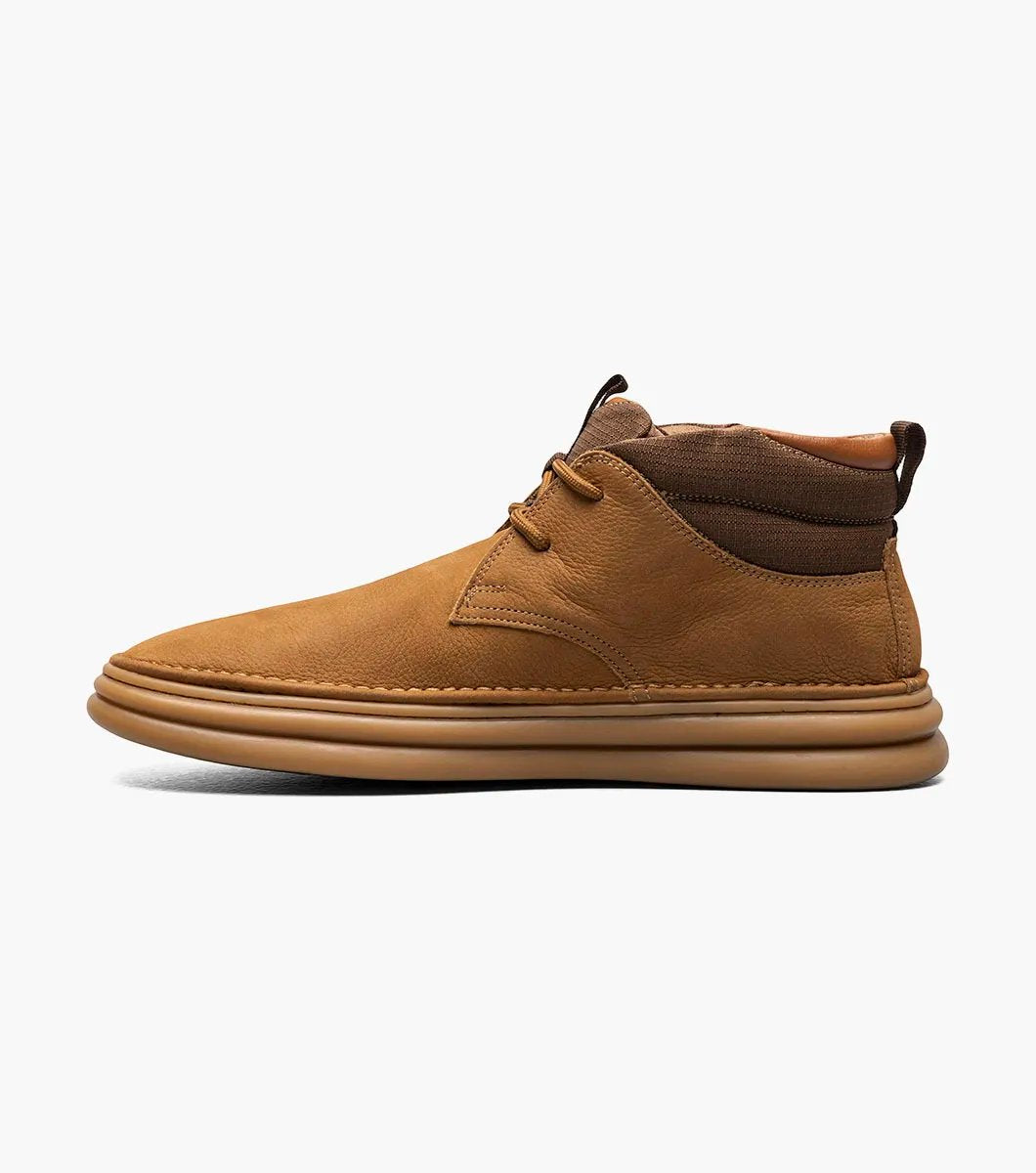 The Stacy Adams DELSON Plain Toe Chukka Boot in camel features a sleek brown suede leather upper with matching laces and a tan rubber sole, showcased from a frontal perspective.