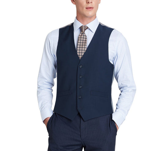 A person wearing the Renoir Alessandro Vitello navy business suit vest in a regular fit, made from polyester viscose, layered over a blue striped shirt with a patterned tie, hands in pockets.