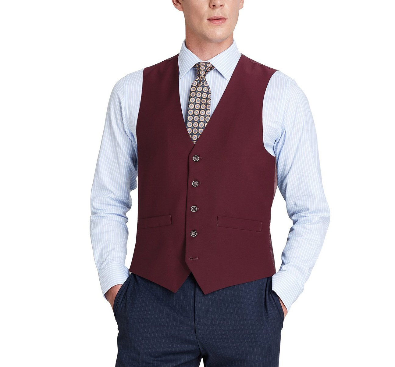 A person wearing the Alessandro Vitello Burgundy Business Suit Vest by Renoir, paired with a light blue striped shirt, patterned tie, and dark pants, is standing with hands in pockets. The regular fit waistcoat accentuates the elegance of its polyester viscose fabric.