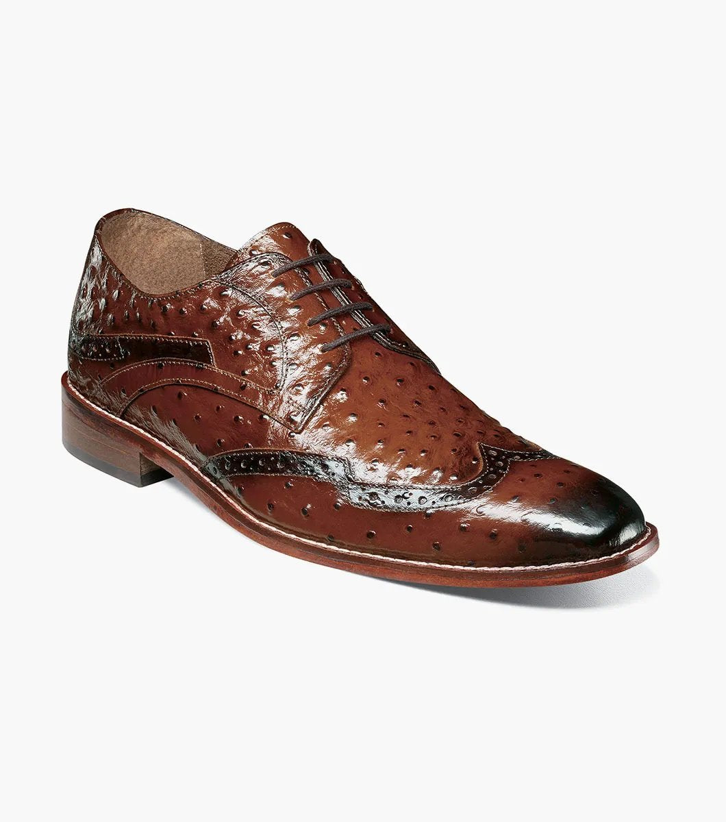 The Stacy Adams GENNARO Wingtip Oxford in cognac showcases a brown ostrich quill print leather design with intricate brogue detailing and a lace-up closure, complemented by anatomical arch support, offering an elegant side view.