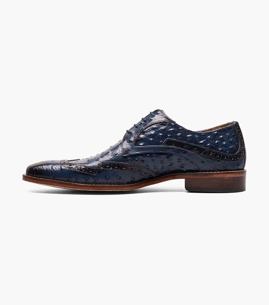 This blue Stacy Adams Gennaro Wingtip Oxford, featuring a textured ostrich quill print finish and a brown sole, elegantly captures the refined style associated with the Stacy Adams brand.