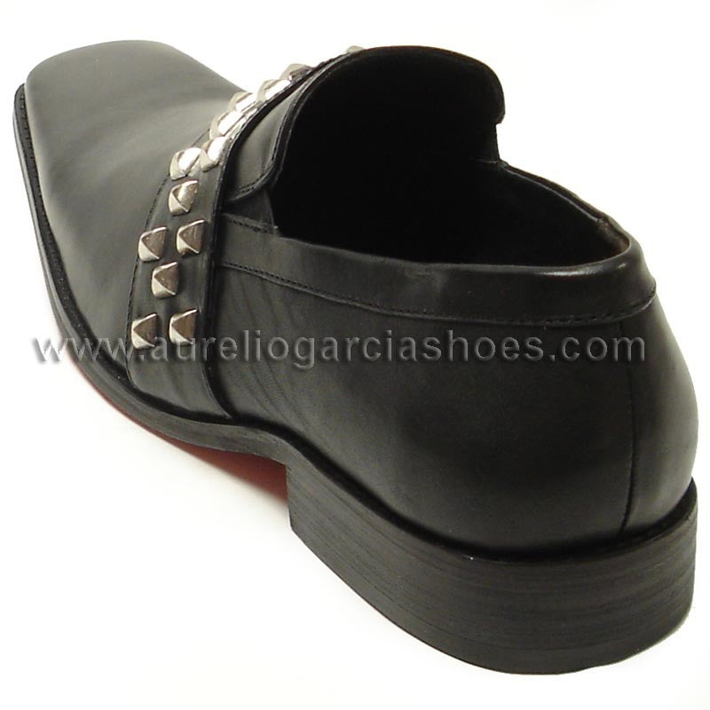 The FI-6563 Black Fiesso by Aurelio Garcia from the Fiesso brand is a slip-on leather shoe adorned with a band of silver studs across the top. It features a pointed toe and low heel, blending style and comfort with its cushioned insole.