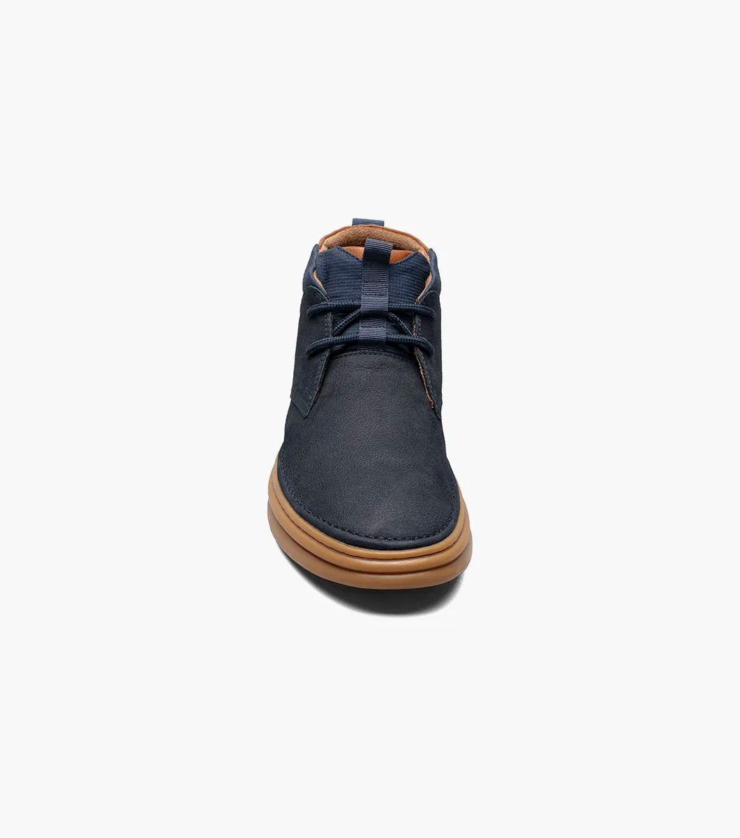 The Stacy Adams DELSON Plain Toe Chukka Boot in Navy showcases a leather upper paired with brown soles and laces, featuring anatomical arch support, set against a white background.