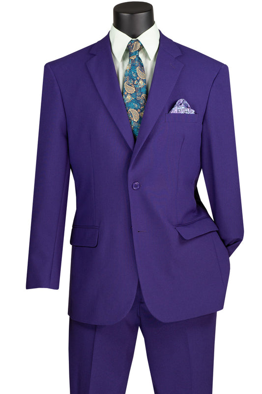 The Vinci Single Breasted Poplin Dacron Suit (Purple) 2PP from Vinci Suits, boasting a single-breasted design with two buttons, is elegantly showcased on a mannequin. It is paired with a white shirt, patterned blue tie, and matching pocket square, while its flat-front pants complete the sophisticated outfit.