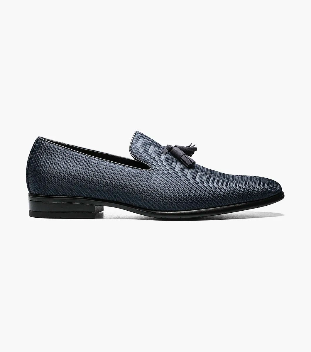 Here's a revised version of the sentence using the provided product data:

A single navy Stacy Adams TAZEWELL Plain Toe Tassel Slip-On loafer, identified by its tassel detail and textured finish, viewed from the side. This loafer features a low heel, sleek design, and cushioned footbed for added comfort.