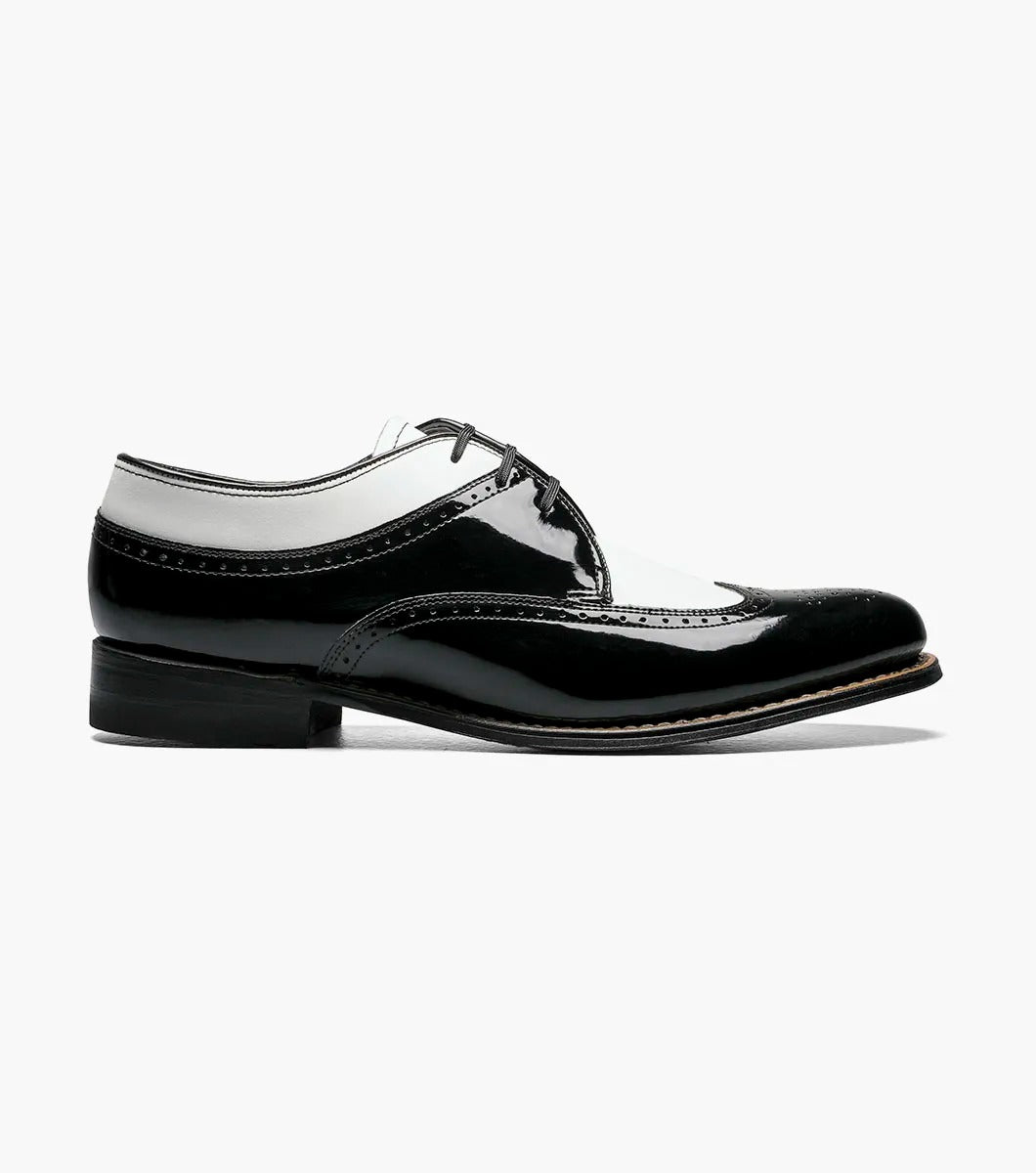 The Stacy Adams - DAYTON Snakeskin Wingtip Oxford in black and white is a sophisticated shoe from STACY ADAMS, expertly crafted from premium patent leather. It features a lace-up closure and classic Goodyear welt construction, set against a plain background.