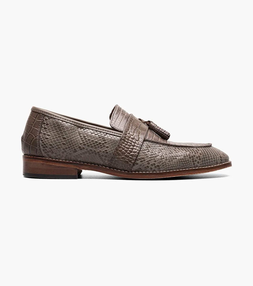 Gray tassel loafer designed by Stacy Adams, made from lizard print leather with dark brown trim and a low heel. It includes a Memory Foam insole for enhanced comfort and is displayed against a plain background.