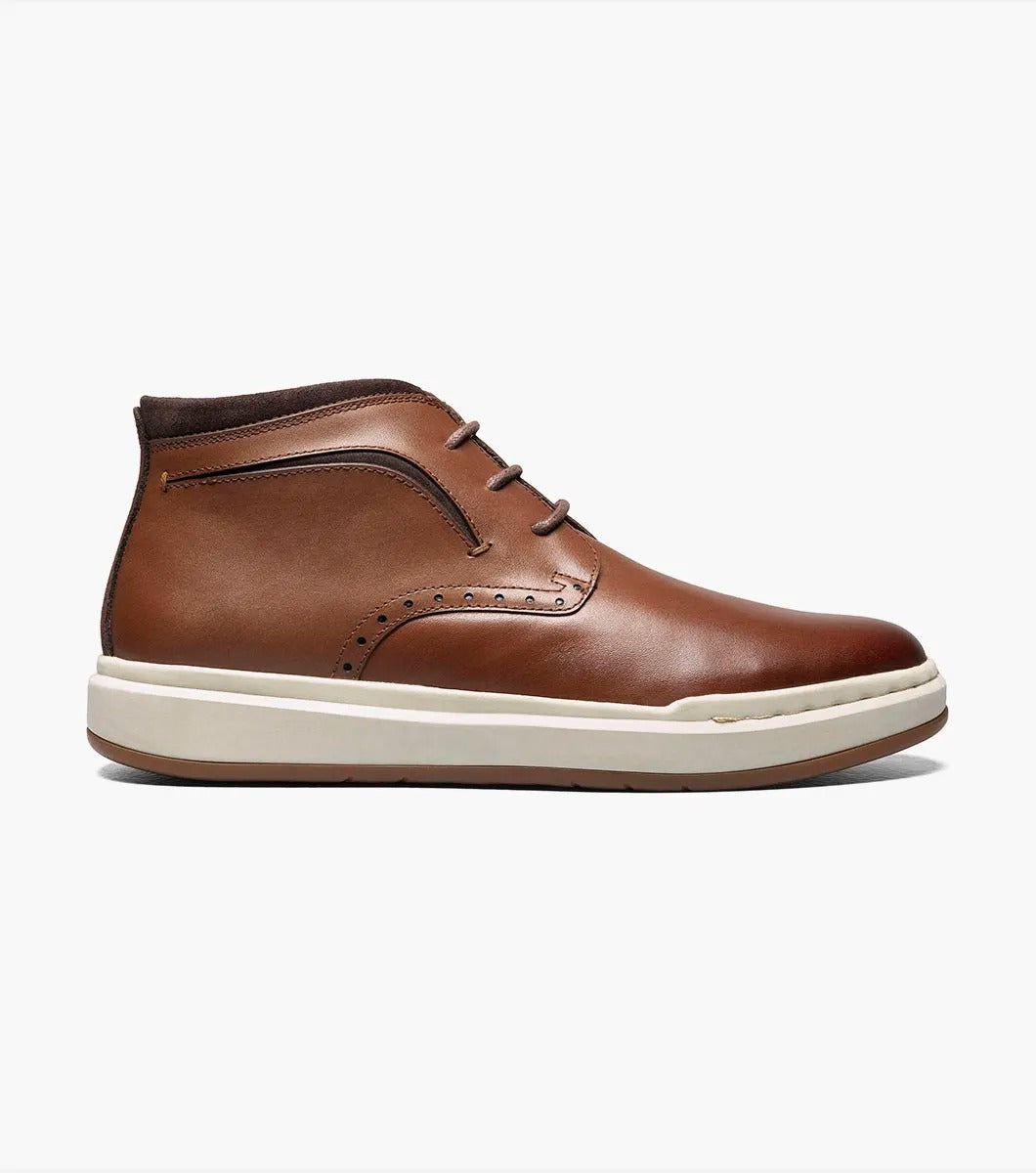 Stacy Adams' CORBIN Plain Toe Chukka Boot features a cognac smooth finish with decorative perforations, a comfortable insole, white sole, and brown laces displayed on a plain white background.