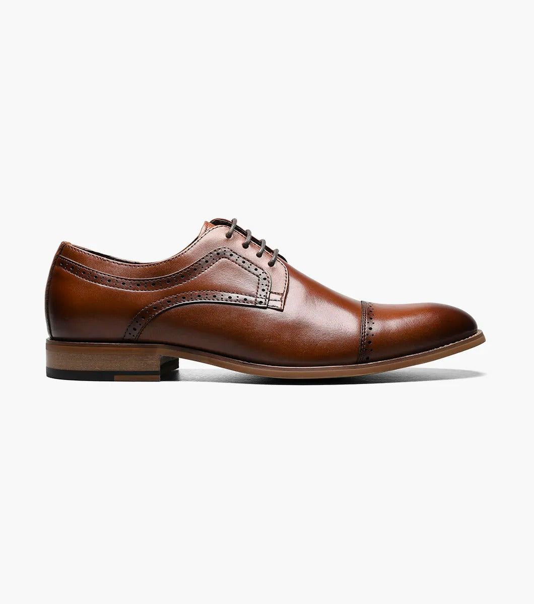 The Stacy Adams - DICKINSON Cap Toe Oxford in Cognac (25066-221) showcases a Leather Upper with decorative perforations, lace-up closure, and Memory Foam for enhanced comfort, all displayed on a white background.