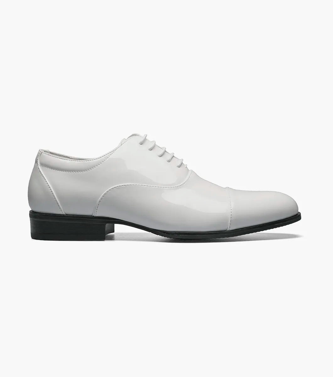 The Stacy Adams GALA Cap Toe Oxford in white patent leather, product number 24998-122, showcases a sleek cap toe design with black laces and a black sole, viewable from the side.