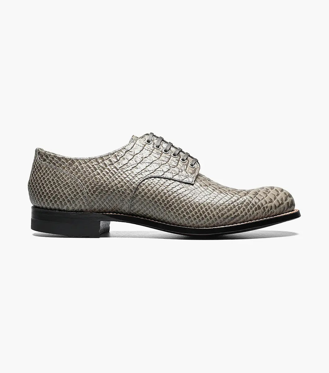 The Stacy Adams Madison Anaconda Plain Toe Oxford in gray showcases a sleek snakeskin pattern, complemented by a black leather outsole and matching laces, all elegantly displayed on a white background.