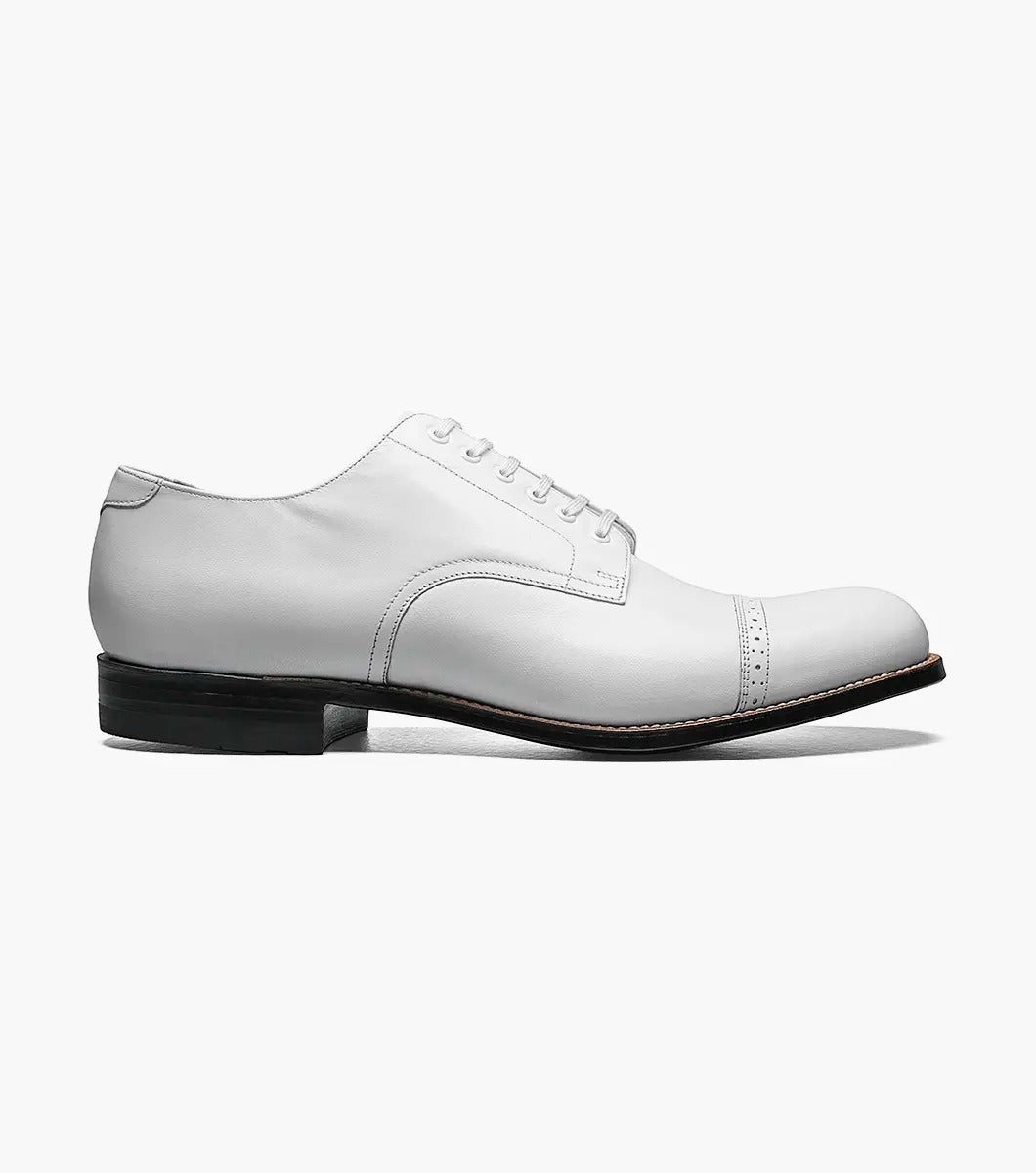 The MADISON Cap Toe Oxford in white, featuring sleek and stylish laces along with a contrasting black sole, embodies the timeless elegance for which STACY ADAMS is renowned.