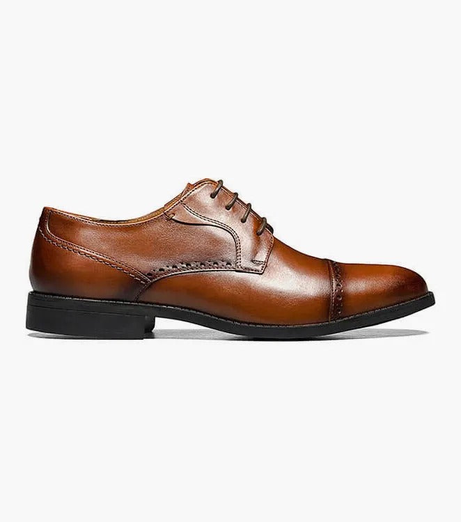 The Stacy Adams BARNETT Cap Toe Oxford in Scotch color, model 20196-232, is a classic brown burnished leather dress shoe with decorative stitching and laces. It features a low heel, smooth sole, and embodies the timeless elegance of a Cap Toe Oxford.