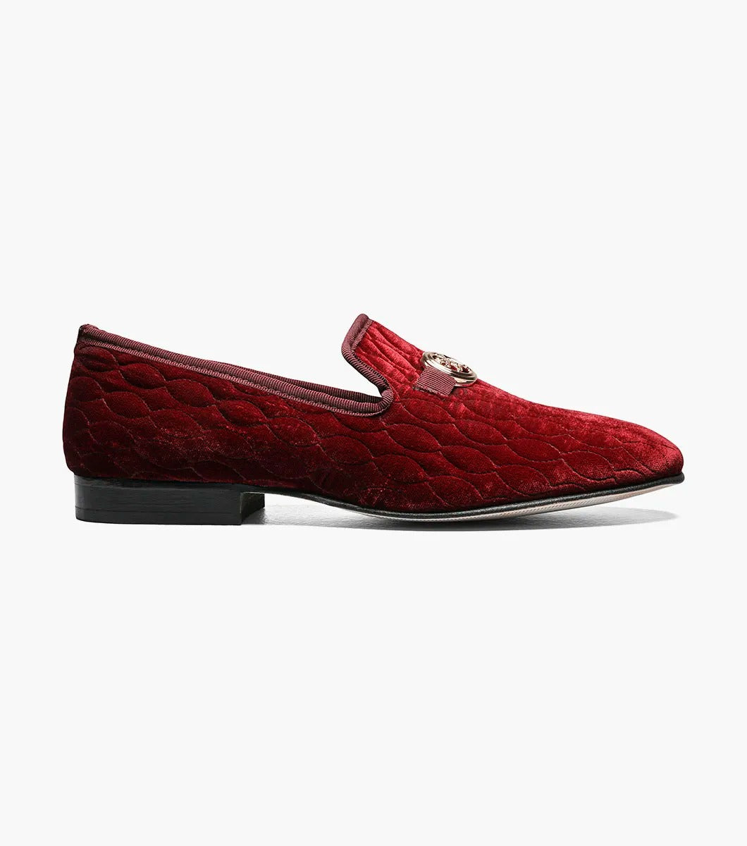 Introducing the Stacy Adams VALET Slip-On Bit Loafer in Burgundy (Product Code: 25166-601), this stylish footwear features a red velvet quilted pattern and is adorned with a gold emblem on the front. Crafted by STACY ADAMS, it boasts a genuine leather sole and incorporates a memory foam insole for enhanced comfort.