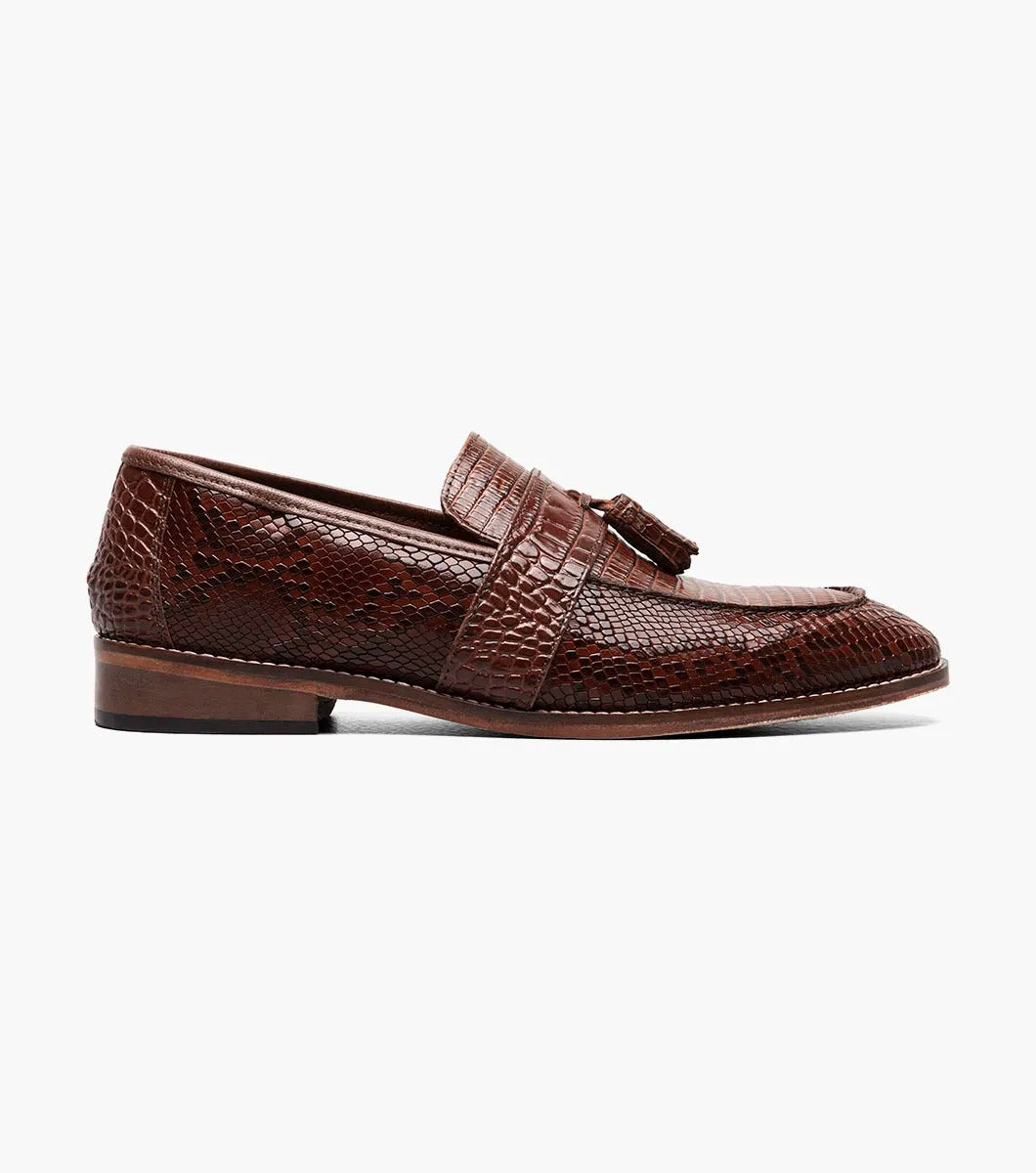 The Stacy Adams - PACETTI Leather Sole Moc Toe Tassel Slip On in Cognac, featuring a textured pattern with tassels on the front and a comfortable memory foam insole, is displayed against a plain white background.