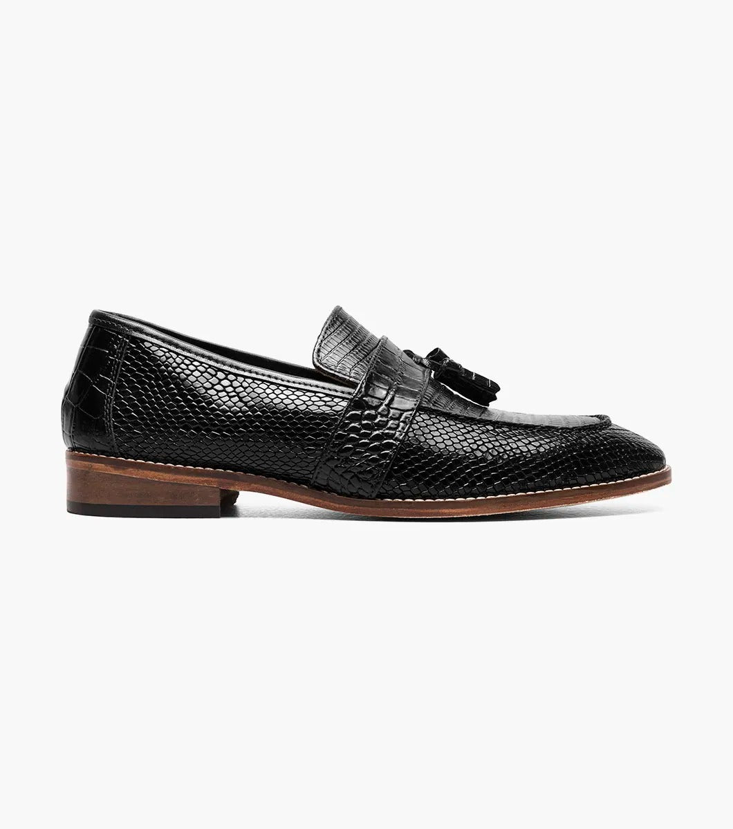 From the Stacy Adams PACETTI collection, this black leather Moc Toe Tassel Slip On loafer features a textured finish, memory foam insole, and brown sole against a white background.