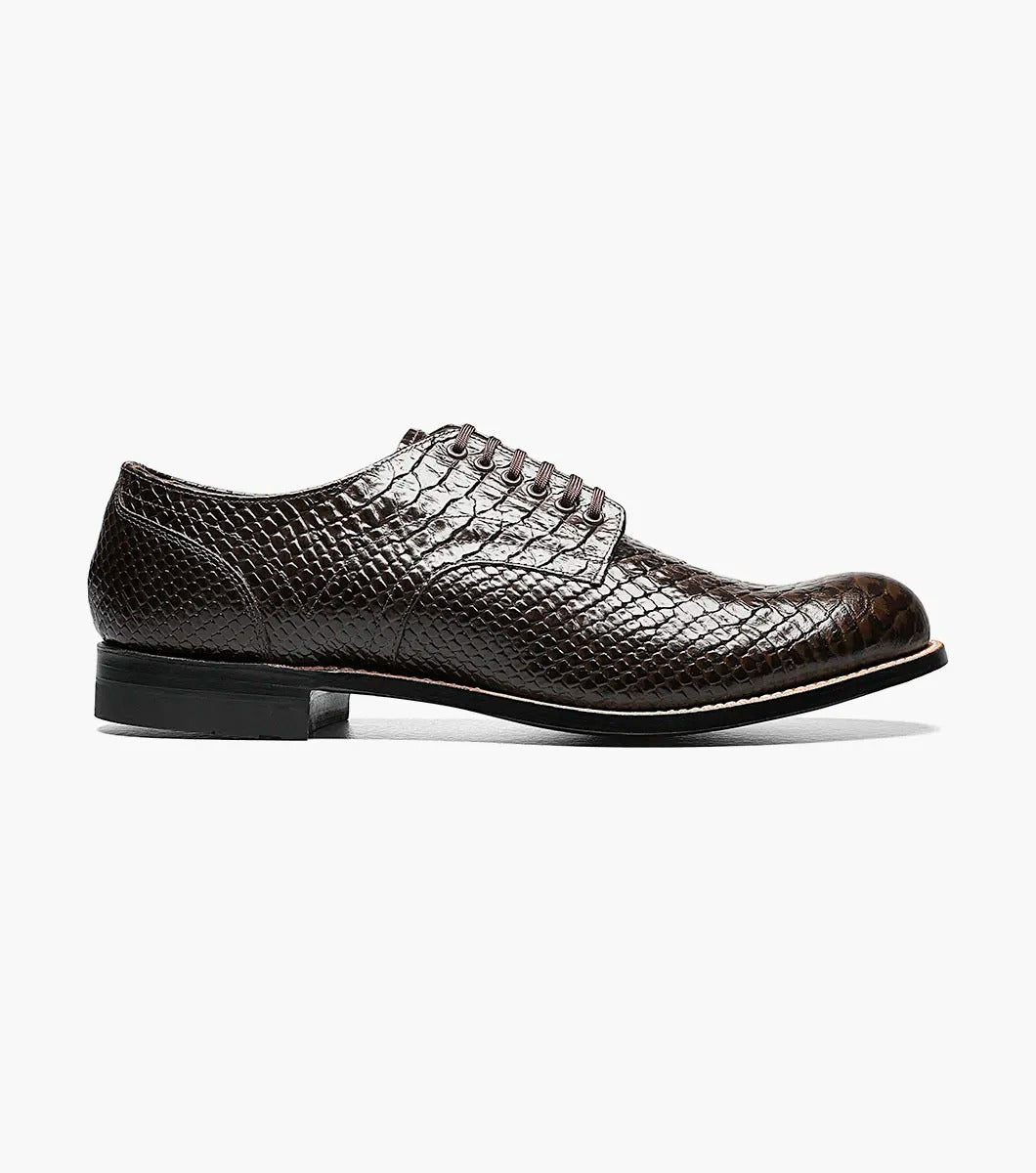 The Stacy Adams MADISON Anaconda Plain Toe Oxford in brown showcases an anaconda print with black laces, set against a white background.