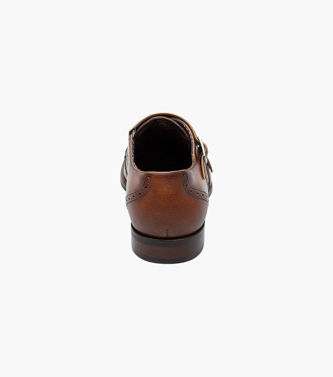 The Stacy Adams - KARSON Wingtip Double Monk Strap in cognac, model number 25570-221, is a shoe crafted with brown leather and features wingtip decorative perforations along with two side buckles, complemented by a RedZone footbed for exceptional comfort.