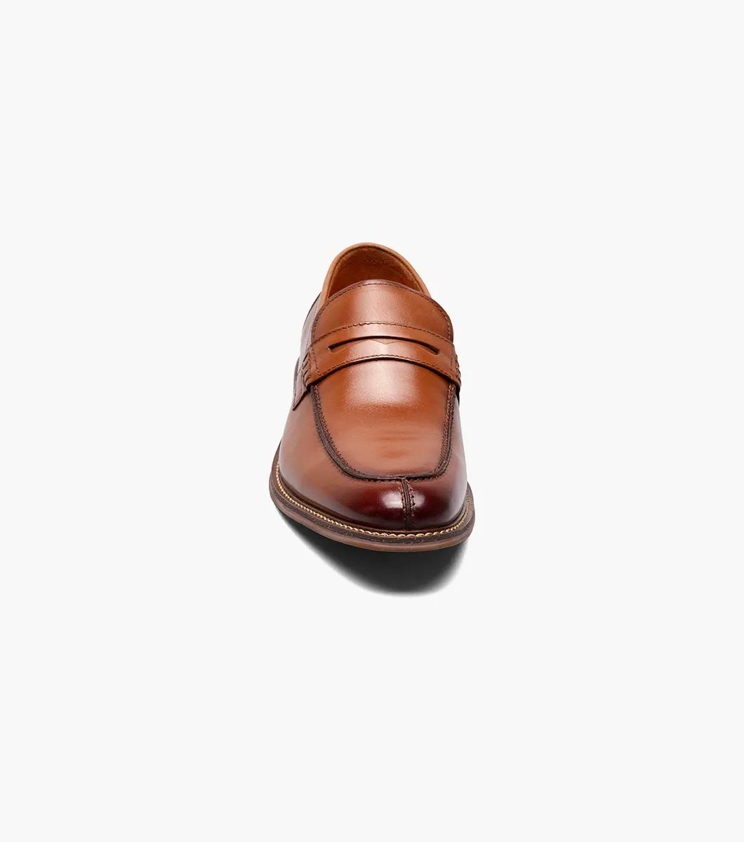 The Stacy Adams - MARLOWE Algonquin Moc Toe Penny Slip On in Cognac, with a leather upper and detailed stitching on a low heel, is showcased against a white background.