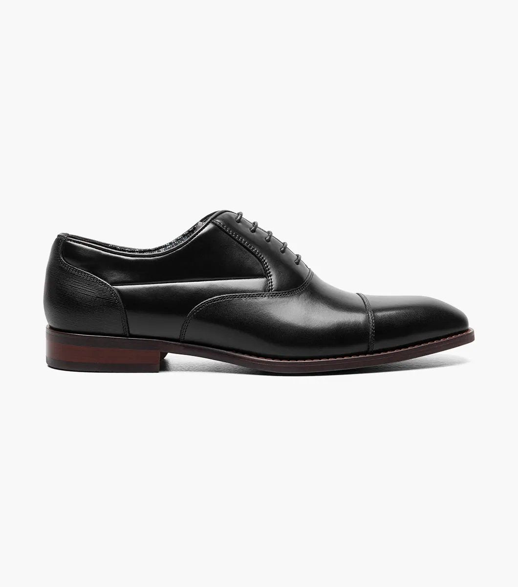 A side view of the Stacy Adams - KALLUM Cap Toe Oxford in black leather, featuring a burnished finish and a dark brown sole.