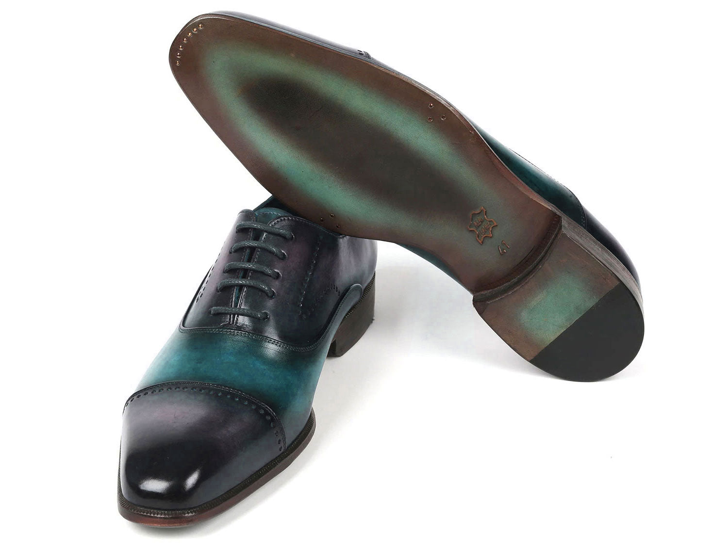 Introducing the Paul Parkman Cap Toe Oxfords in a stunning purple and turquoise combination. Crafted with meticulous attention to detail, these shoes feature hand-painted leather, laces, and decorative perforations that add an elegant touch.