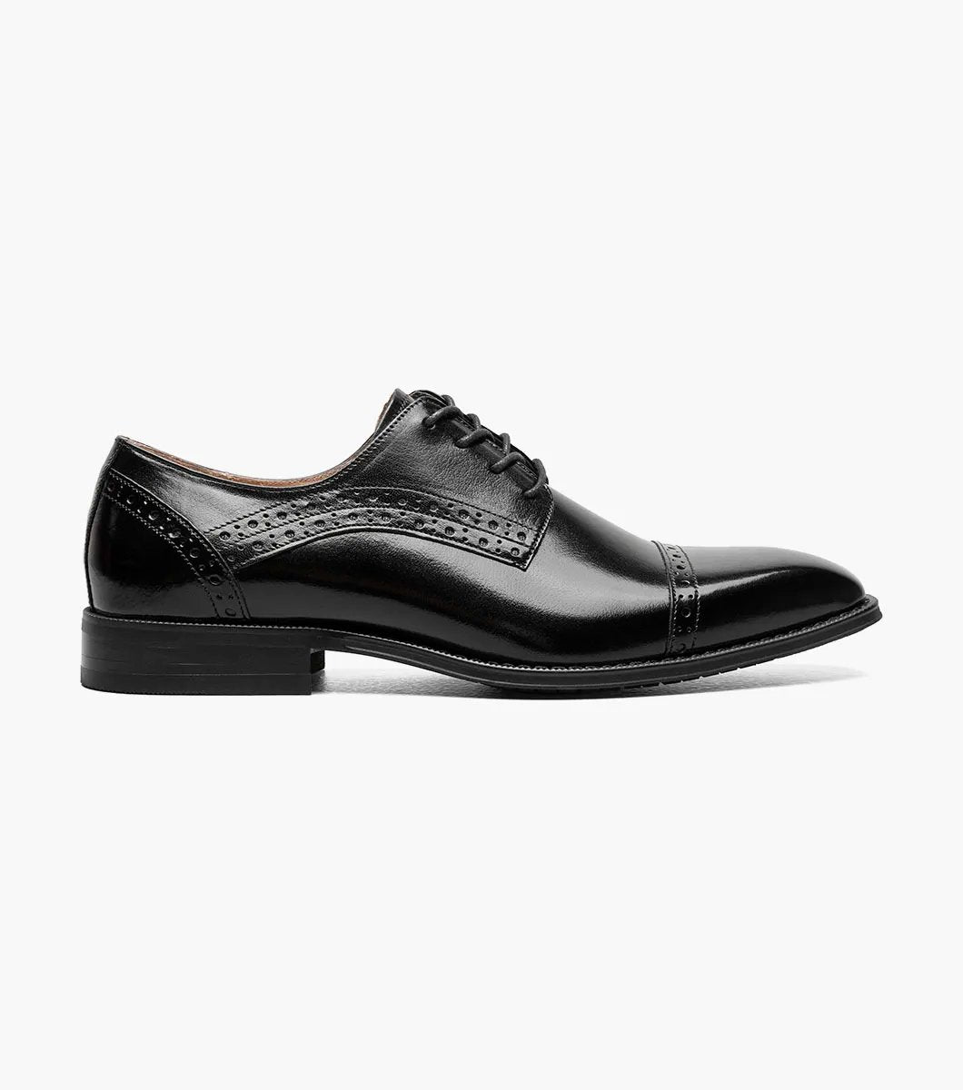 The Stacy Adams - GARRETT Cap Toe Oxford in black, product code 25543-001, is a polished Buffalo leather dress shoe with laces, decorative perforations, and a low heel.