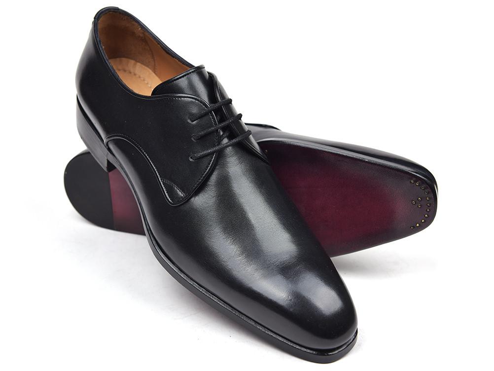 A pair of Paul Parkman Black Leather Derby Shoes - 34DR-BLK in Italian calfskin, featuring classic lace-up styling, with one shoe upright and the other on its side to display the sole.