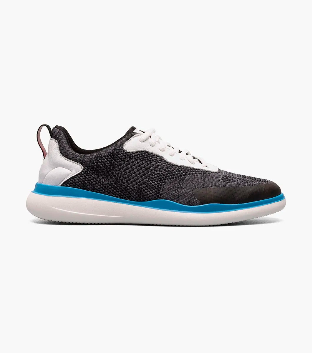 The Stacy Adams - MAXSON Moc Toe Lace Up Sneaker in Black Multi presents a stylish design with a white sole and blue accent, complemented by white laces and a textured mixed material upper for durability. This sneaker also provides anatomical arch support to ensure enhanced comfort with every step.