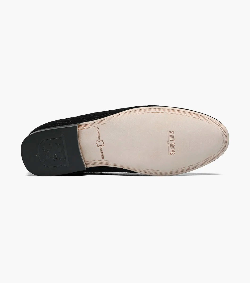 The Stacy Adams VALET Slip On Bit Loafer in Black (25166-001) showcases a black velvet design with a quilted pattern and gold emblem on top, enhanced by a genuine leather sole and cushioned with a Memory Foam insole for superior comfort.