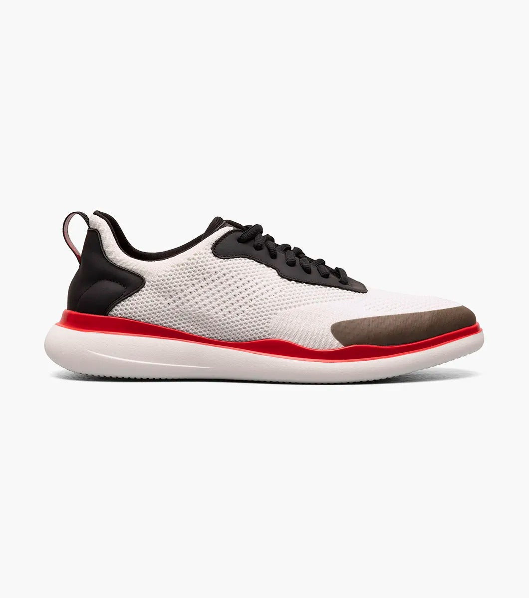 The Stacy Adams - MAXSON Moc Toe Lace Up Sneaker in White Multi (style 25517-110) showcases a sleek design with black accents, a striking red sole, and a distinctive brown toe cap. This hybrid sneaker-casual shoe provides both versatility and comfort, enhanced by the RedZone removable footbed for premium support.