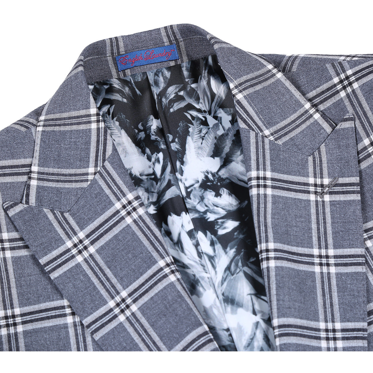 The ENGLISH LAUNDRY Dimgray with White Check Peak Suit 72-60-001 by English Laundry is a slim fit suit jacket in gray plaid, lined with a light blue and white abstract pattern. It features peak lapels, two buttons, and two front pockets.