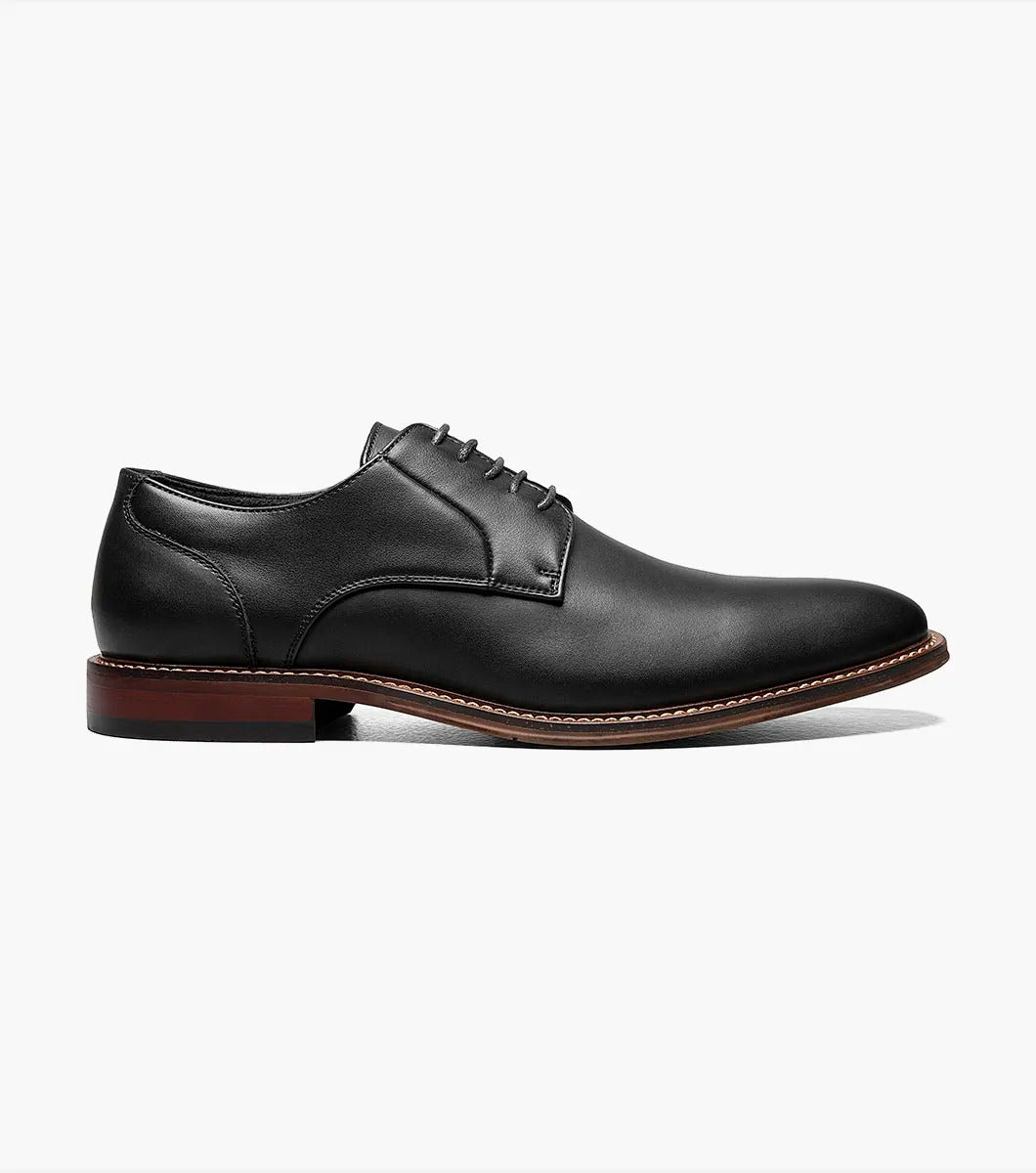 A single Stacy Adams - MARLTON Plain Toe Oxford in black leather, featuring laces, a burnished finish, brown sole, slight heel, and anatomical arch support is displayed on a plain white background.