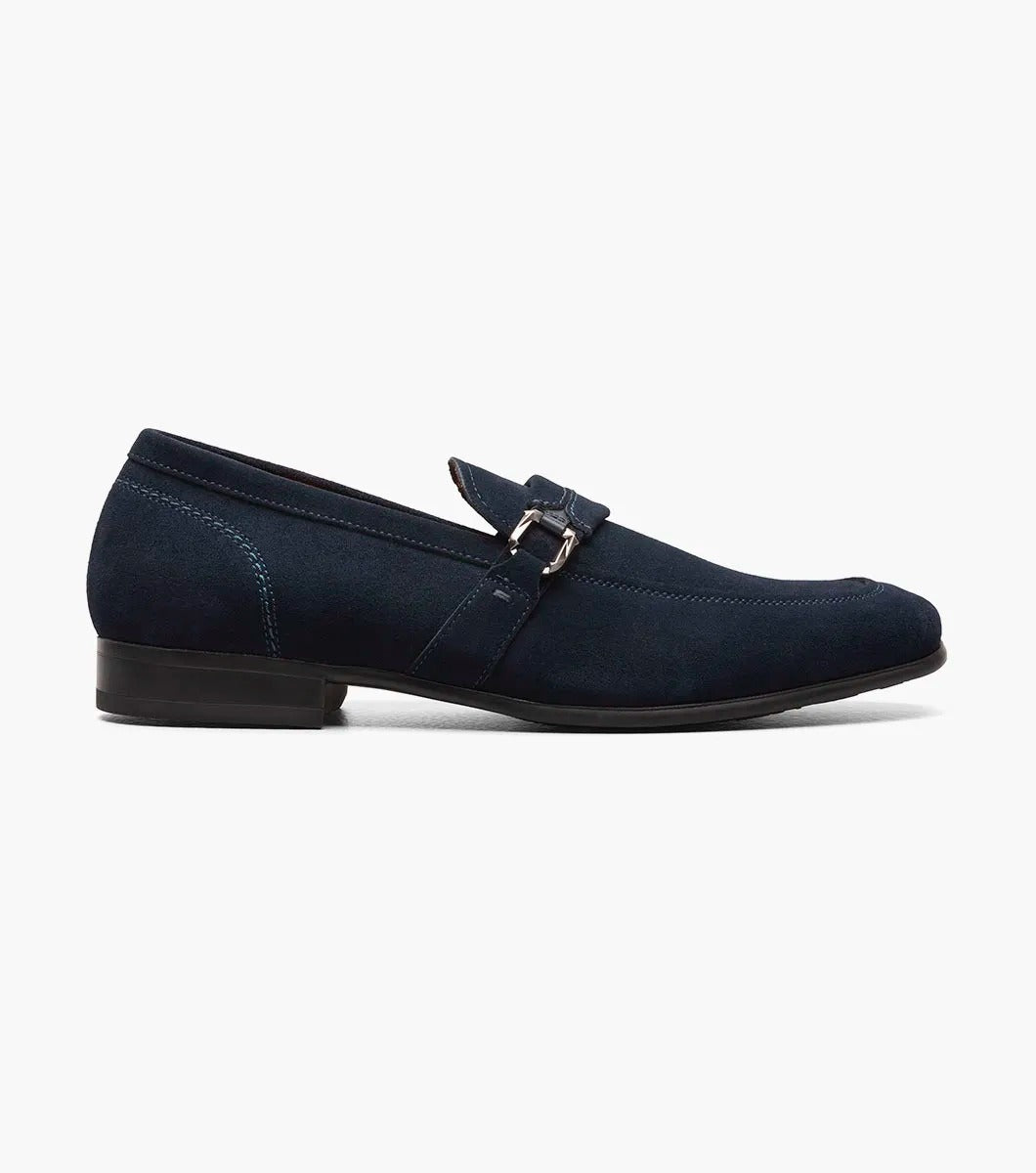 The Stacy Adams - QUILLAN Moc Toe Ornament Slip On features navy suede with a durable rubber outsole, embellished with a small metal buckle and complemented by a low black heel.