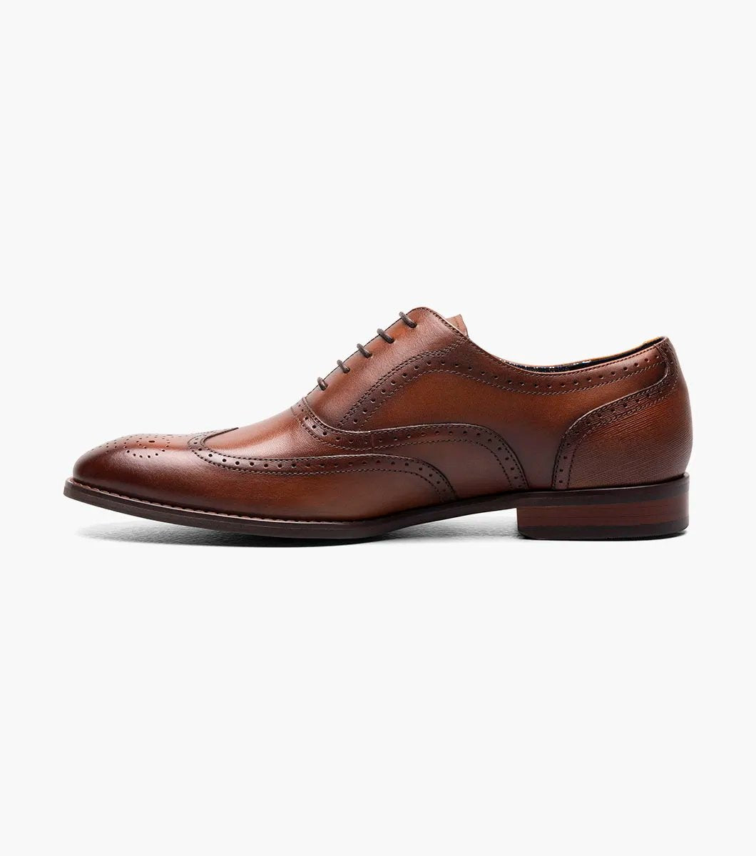 The Stacy Adams KAINE Wingtip Oxford in Cognac, model number 25569-221, from STACY ADAMS, is showcased against a white background, highlighting its intricate stitching and decorative perforations.