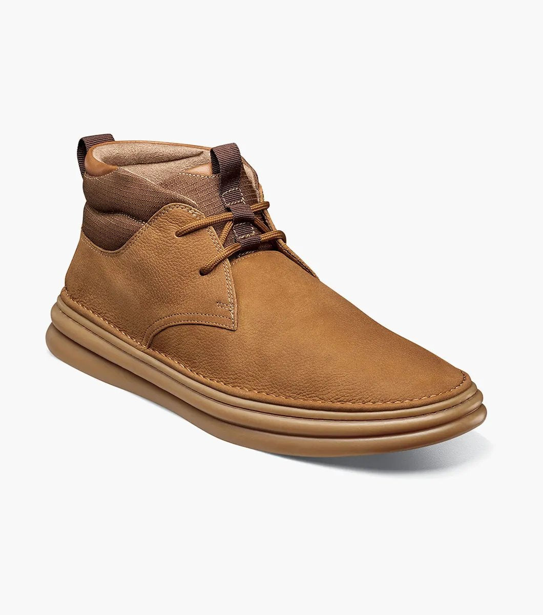 The Stacy Adams DELSON Plain Toe Chukka Boot in Camel (model 25556-228) has a durable rubber sole and lace-up front, offering anatomical arch support for all-day comfort against the crisp white background.