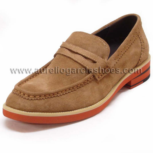 The FI-6703 Brown Fiesso by Aurelio Garcia from the Fiesso brand is a men's casual leather shoe featuring a brown suede loafer style with a slip-on design and penny slot. It boasts detailed stitching, an orange sole, and a cushioned insole for added comfort.