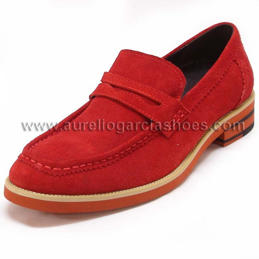 The FI-6703 Red Fiesso By Aurelio Garcia from Fiesso is a men's casual leather shoe featuring a red suede loafer design with a tan and orange sole, detailed stitching, and a decorative strap across the top. This shoe seamlessly blends style and comfort, making it perfect for any occasion.