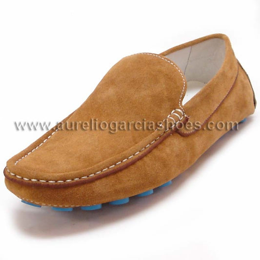 The FI-3117 Brown Encore by Fiesso is a casual driving shoe that boasts a brown suede loafer design, highlighted with visible stitching and blue sole accents, along with a cushioned insole for ultimate comfort.