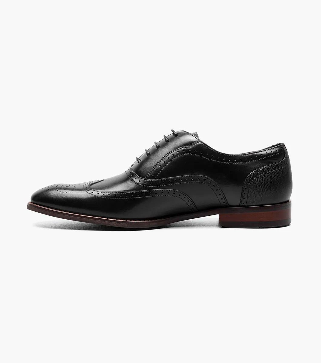 Presenting the Stacy Adams - KAINE Wingtip Oxford in Black, style number 25569-001, from STACY ADAMS. This shoe boasts a classic wingtip design with decorative perforations and laces, featuring a low heel and sleek profile. It is crafted for comfort with anatomical arch support.