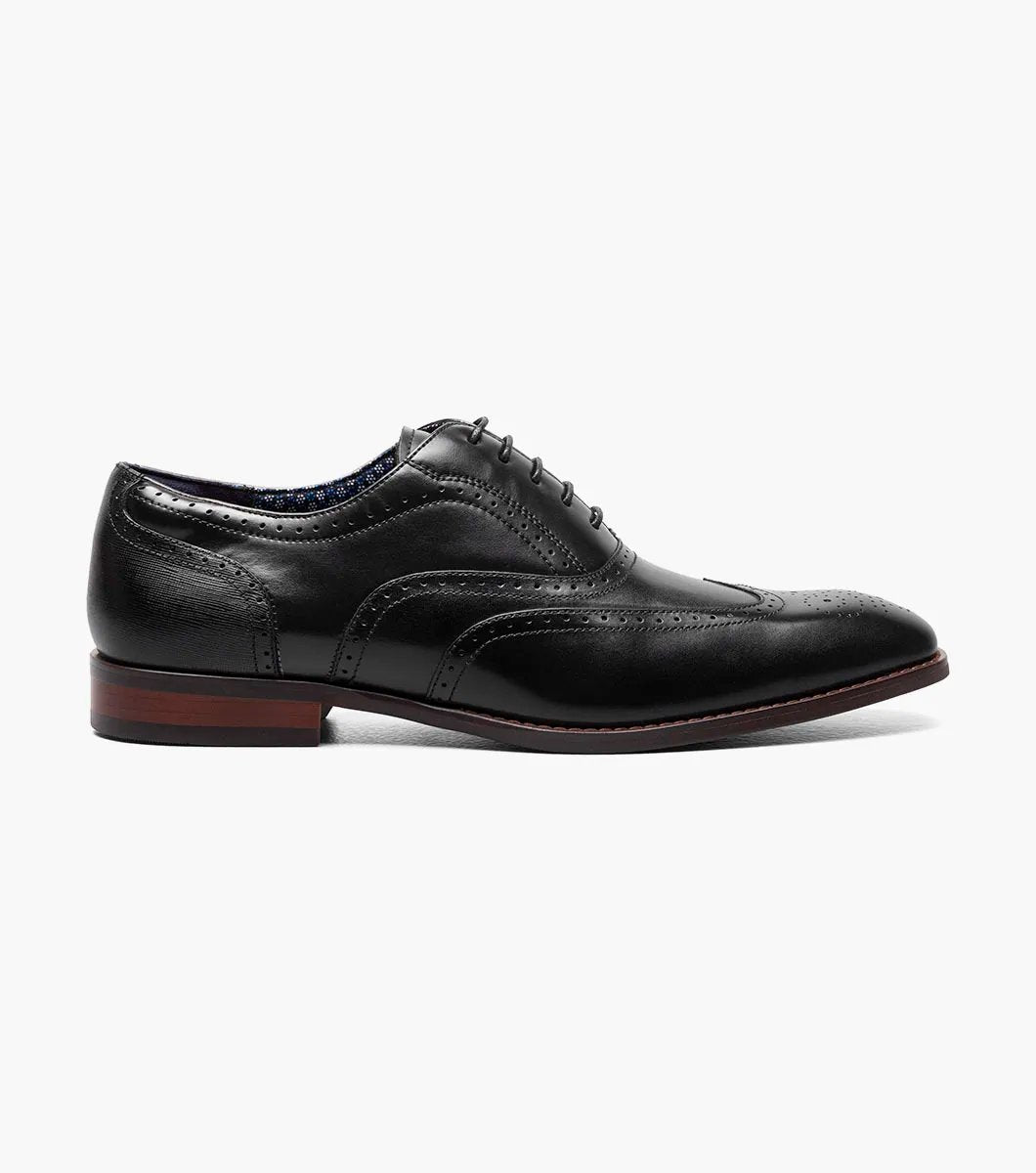 Presenting the Stacy Adams - KAINE Wingtip Oxford in Black, style number 25569-001, from STACY ADAMS. This shoe boasts a classic wingtip design with decorative perforations and laces, featuring a low heel and sleek profile. It is crafted for comfort with anatomical arch support.