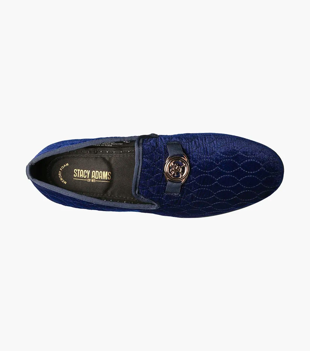 The Stacy Adams VALET Slip On Bit Loafer, model 25166-400, combines quilted velour in a striking blue with a sleek black sole and is elegantly decorated with a gold emblem on top. It also features a Memory Foam insole for enhanced comfort.