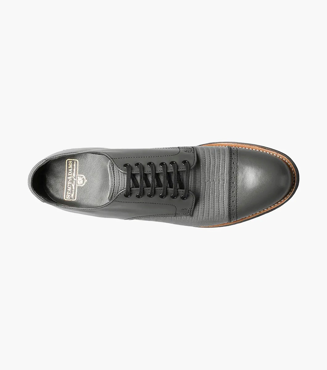 Introducing the Stacy Adams MADISON Lizard Cap Toe Oxford in Steel Gray, a sophisticated leather lace-up dress shoe from STACY ADAMS, meticulously designed with kidskin leather and featuring a detailed cap toe and a sleek black sole.