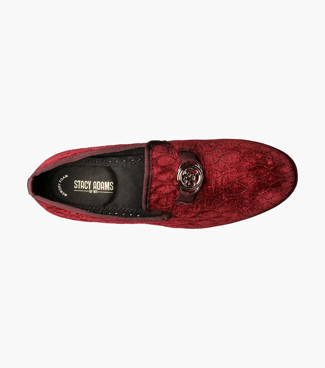 Introducing the Stacy Adams VALET Slip-On Bit Loafer in Burgundy (Product Code: 25166-601), this stylish footwear features a red velvet quilted pattern and is adorned with a gold emblem on the front. Crafted by STACY ADAMS, it boasts a genuine leather sole and incorporates a memory foam insole for enhanced comfort.