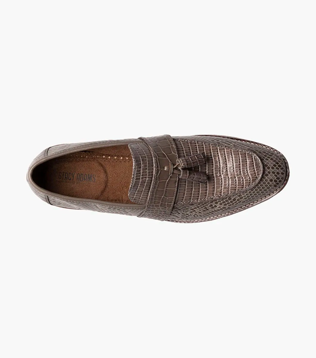 Gray tassel loafer designed by Stacy Adams, made from lizard print leather with dark brown trim and a low heel. It includes a Memory Foam insole for enhanced comfort and is displayed against a plain background.