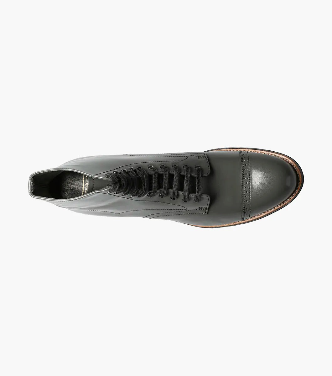 The Stacy Adams MADISON Cap Toe Boot in Steel Gray, made from high-quality kidskin leather, showcases a sophisticated lace-up design and a polished cap toe, enhanced by a sturdy black sole set against a crisp white backdrop.