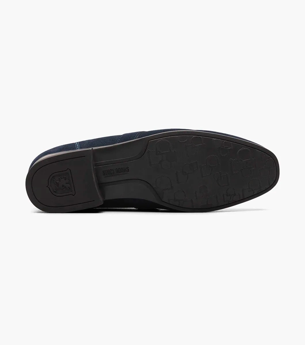 The Stacy Adams - QUILLAN Moc Toe Ornament Slip On features navy suede with a durable rubber outsole, embellished with a small metal buckle and complemented by a low black heel.