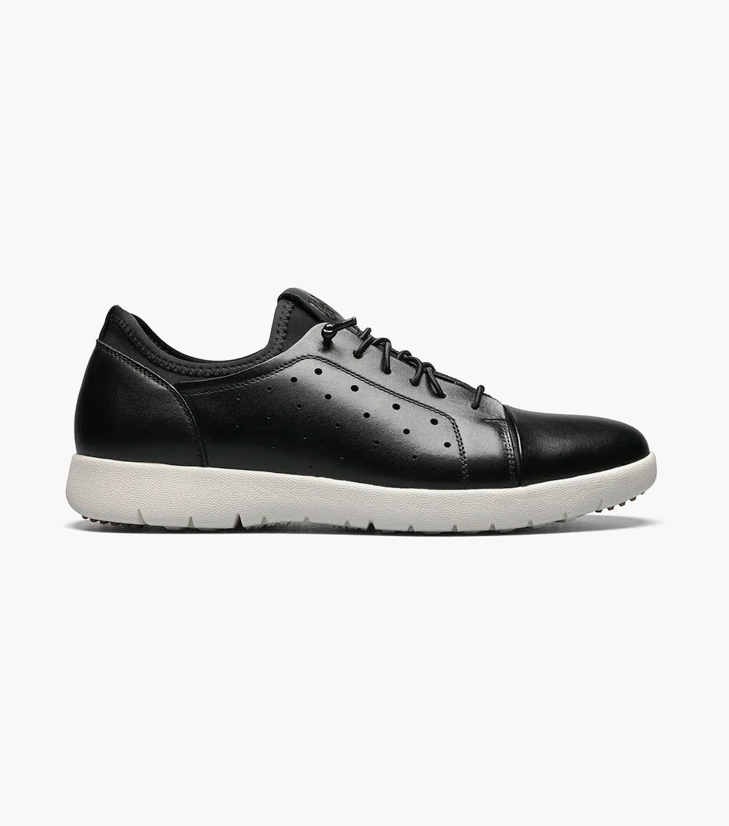 The Stacy Adams - HALDEN Lace Up Sneaker in black showcases a burnished leather upper and perforated side details, set against a plain white backdrop. It features a white rubber sole and cushioned footbed for optimal comfort.