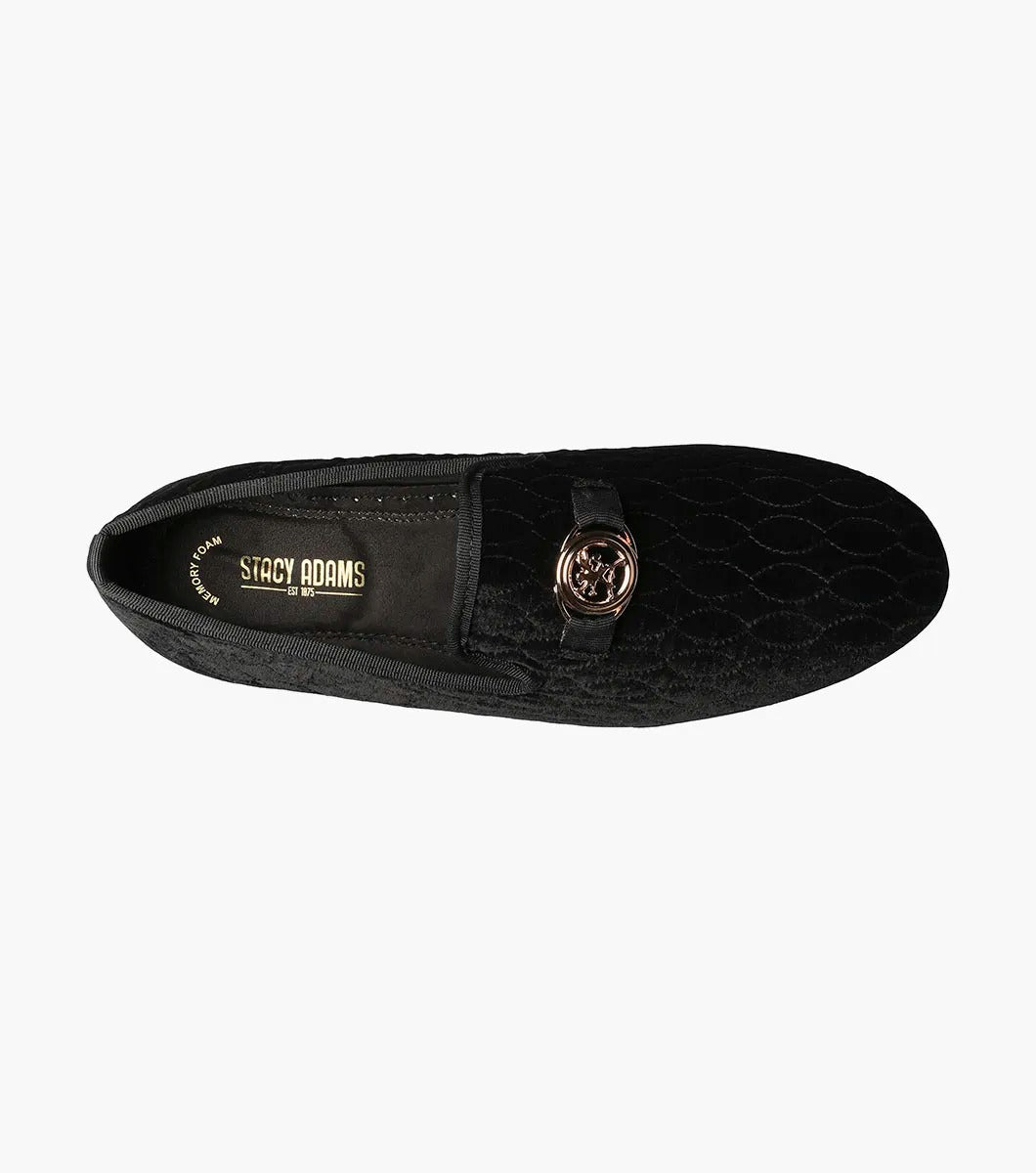 The Stacy Adams VALET Slip On Bit Loafer in Black (25166-001) showcases a black velvet design with a quilted pattern and gold emblem on top, enhanced by a genuine leather sole and cushioned with a Memory Foam insole for superior comfort.