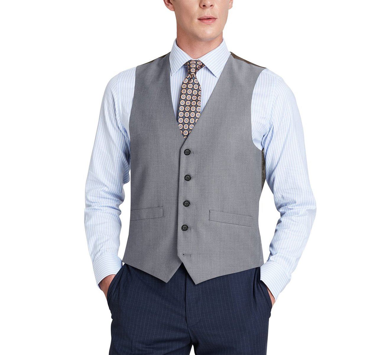 A man wearing the Alessandro Vitello by Renoir Light Grey Wool Suit Vest, a regular fit dress waistcoat over a striped shirt, paired with a patterned tie and hands in pockets.